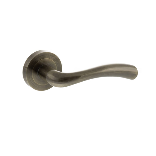 STATUS Texas Lever Door Handle on Round Rose - Antique Brass - Depth: 59mm, Height: 51mm, Width: 141mm
